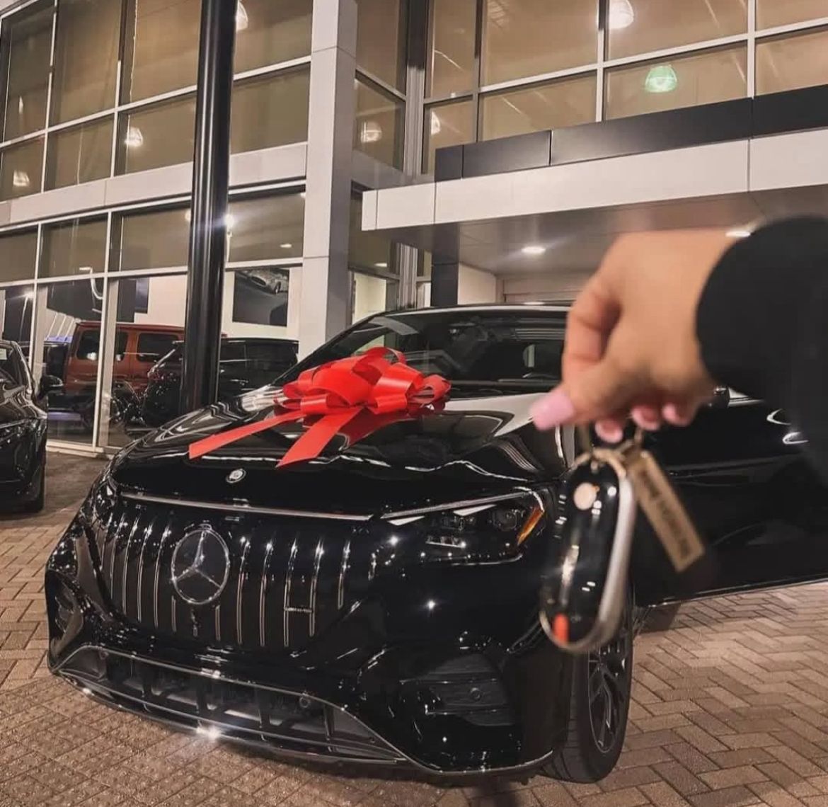Client's Mercedes AMG purchase at dealership with red bow